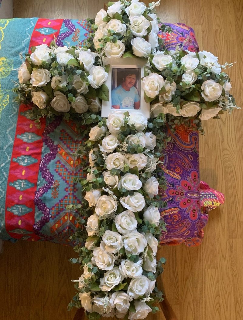 White rose memorial cross with a photograph at its center