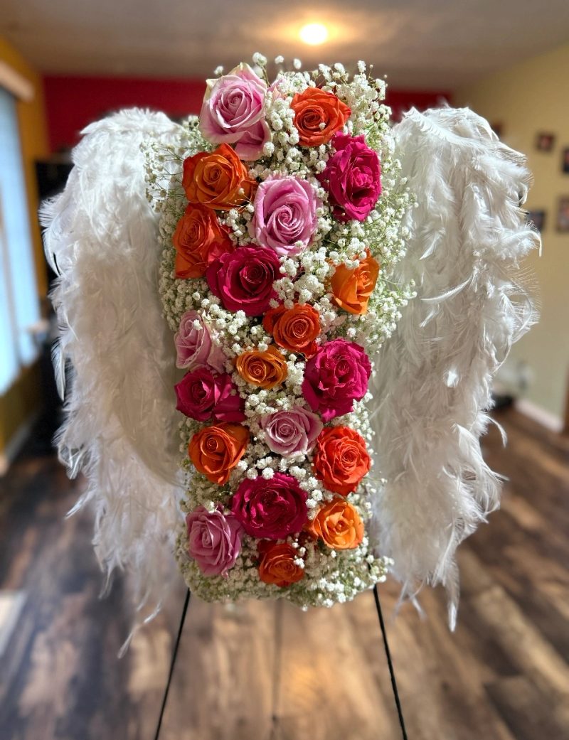 Angel-wing arrangement with pink, red, and orange roses